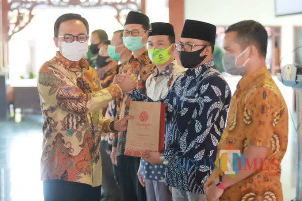 Penyerahan Cinderamata oleh Bupati Pamekasan kepada Peneliti Musoffan selaku peneliti STIE Bakti Bangsa (Foto:Ist/JatimTIMES.com)