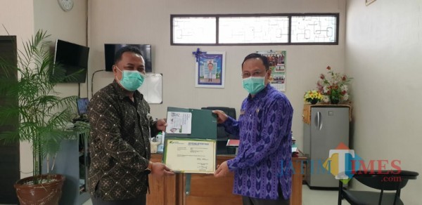 Kepala BPJS Ketenagakerjaan Cabang Kediri Agus Suprihadi menyerahkan bukti kepesertaan kepada kepala RS.Gambiran.(ist)