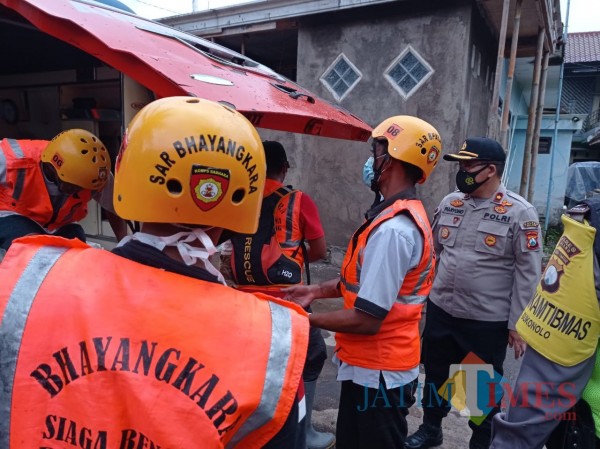 Kapolsek Bululawang, Kompol Pujiyono (tengah bertopi) saat mengevakuasi mayat terhanyut di sungai (Hendra Saputra)
