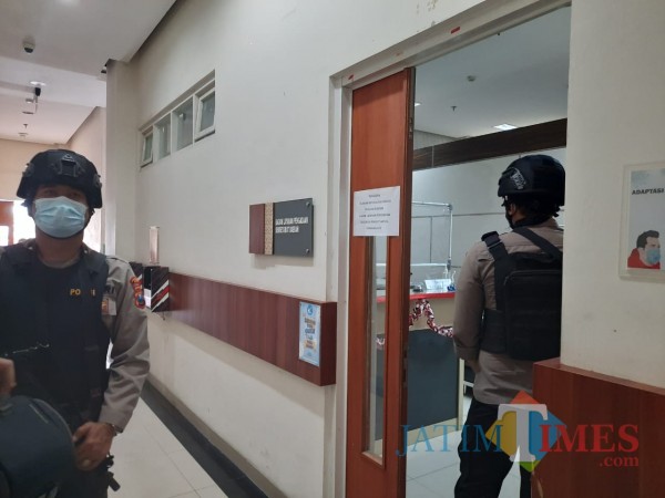 Dua petugas Polres saat berjaga di depan ruang Bagian Layanan Pengadaan Setda Kota, Selasa (12/1/2021). (Foto: Irsya Richa/MalangTIMES)