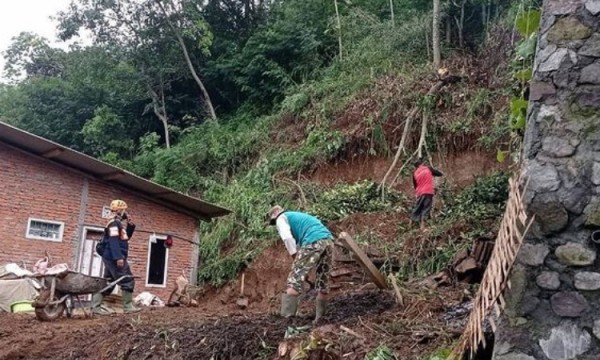 Petugas bersama warga saat membersihkan reruntuhan material tanah longsor di Kecamatan Bumiaji, Senin (11/1/2021). (Foto: istimewa)