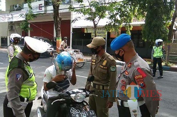 Petugas gabungan saat memberhentikan warga yang tidak memakai masker (Foto:Istimewa/JatimTIMES.com)
