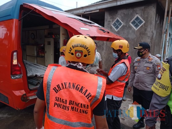 Kapolsek Bululawang, Kompol Pujiyono (tengah bertopi) saat mengevakuasi mayat terhanyut di sungai Senin (11/1/2021) (Hendra Saputra)