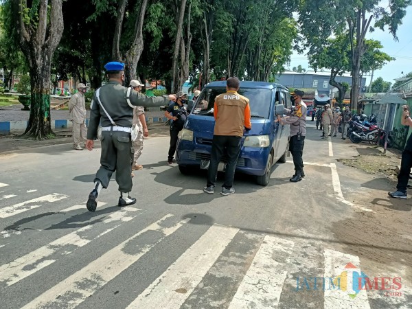 Petugas gabungan sewaktu menjaring pengendara roda empat yang kedapatan melanggar prokes covid-19 (Foto: Syaiful Ramadhani/ JatimTIMES)