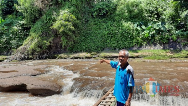 Suhamim saat menunjukkan lokasi penemuan mayat perempuan tanpa identitas di perairan Sungai Brantas, Minggu (7/2/2021). (Foto: Tubagus Achmad/ MalangTIMES)