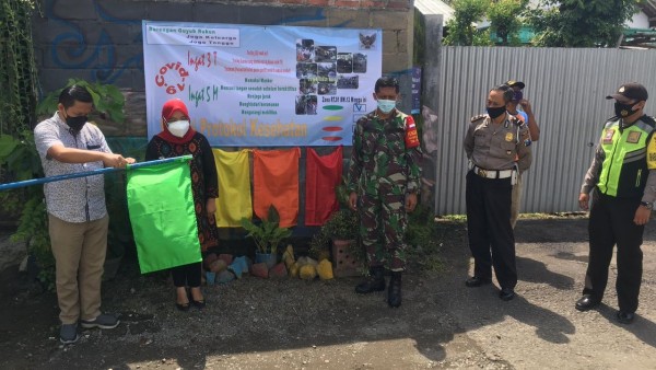 Empat berndera berwarna merah, oranye, kuning dan hijau sebagai penanda kondisi Covid-19 di masing-masing wilayah Kelurahan Burengan. (Foto: Ist)