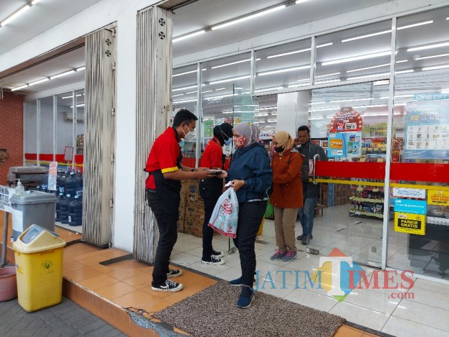 Pegawai Alfamart saat membagikan takjil nasi kotak kepada pengunjung.