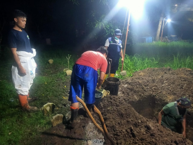 Petugas pemakaman UPT PPU DLH Kota Malang yang tengah melakukan pemakaman hingga malam hari (Ist)