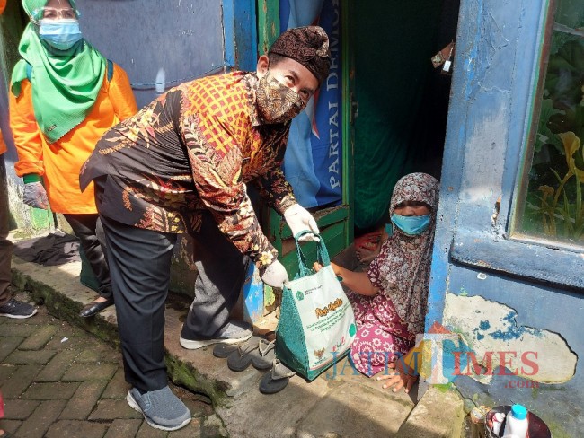 Kepala Kantor Kemenag Kota Malang Muhtar Hazawawi saat memberikan paket sembako kepada warga di Kampung Qoriyah Sakinah.