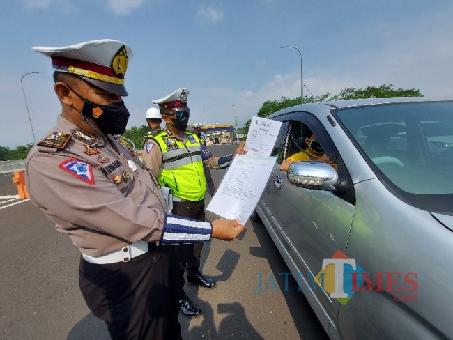 Petugas Pos Pengamanan Exit Tol Madyopuro Malang saat memeriksa kelengkapan dokumen perjalanan.