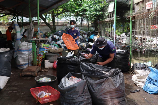 Petugas Bank Sampah (BSM) sebagai mitra Dinas Lingkungan Hidup saat melakukan penyortiran sampah plastik untuk didaur ulang.