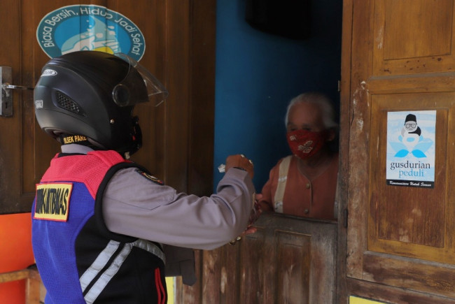 Petugas dari Polres Kediri menyerahkan daging hewan kurban ini secara door to door kepada warga yang berhak menerima. (Foto: Ist)