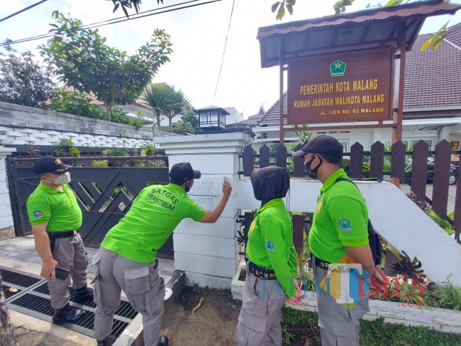 Petugas Satgas Trantibum Satpol PP Kota Malang saat melakukan pembersihan coretan di dinding Rumah Dinas Wali Kota Malang.