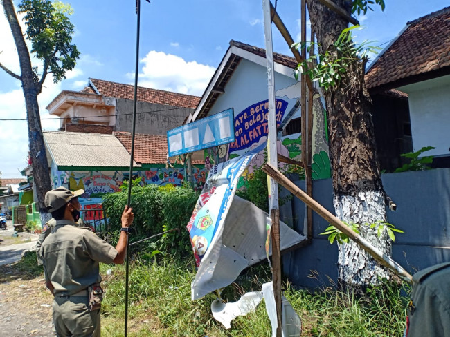 Personel Satpol PP Kabupaten Malang saat menertibkan papan reklame tak berijin.(Foto: Istimewa).