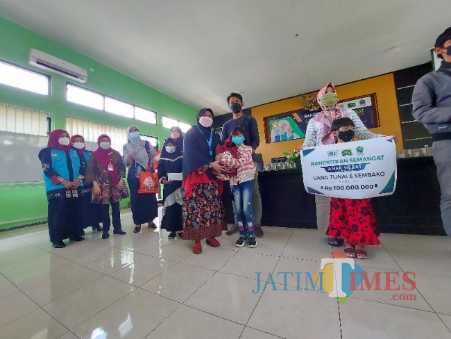 Perwakilan YDSF Malang saat menyerahkan bantuan uang tunai Rp 400 ribu dan sembako.