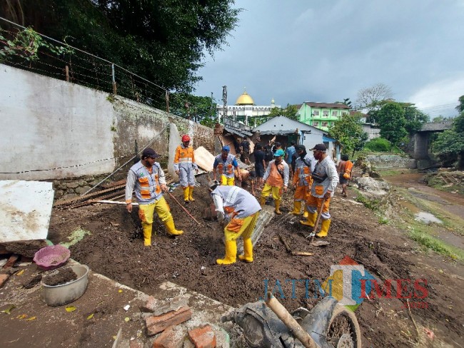 Petugas DLH Kota Malang bersama masyarakat membersihkan puing-puing reruntuhan rumah Rohman yang sudah rata dengan tanah. 