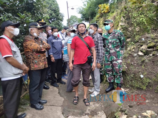 Bupati Malang HM. Sanusi saat menerima keterangan dari Kepala Desa Karangkates Sudjojo Fakrim.(Foto: Riski Wijaya/MalangTIMES).