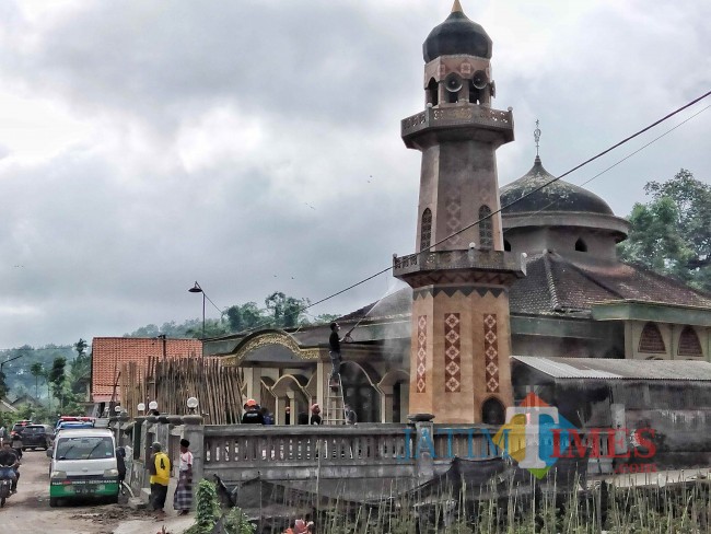 Masyarakat dibantu sejumlah relawan saat membersihkan salah satu masjid yang turut terkena dampak abu vulkanik.(Foto: Riski Wijaya/MalangTIMES).