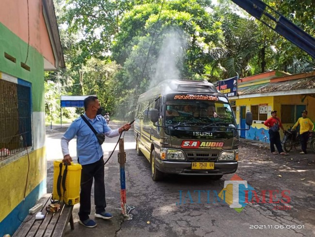 Antisipasi pengelola wisata Pantai Balekambang dengan menyemprot cairan disinfektan pada kendaraan yang masuk.(Foto: Riski Wijaya/MalangTIMES).