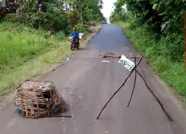 Jalan akses keluar Pantai Ngliyep yang di aspal (foto: potongan video) 