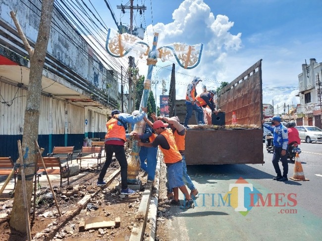 Pemasangan lampu taman kota oleh petugas di Jalan Jenderal Basuki Rahmat, Kota Malang.