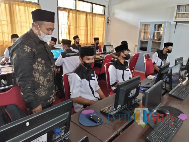 Kepala SMK Terpadu Al-Islahiyah Muhammad Nashrulloh saat menijau proses pembelajaran siswa jurusan TKJ.(Foto: Riski Wijaya/MalangTIMES).