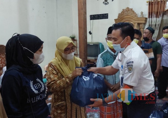 Humas Daop 7 Madiun saat menyerahkan bantuan ke warga.