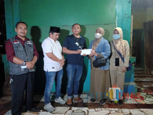 Tim Rumah Sedekah NU saat menyerahkan bantuan untuk pelunasan tunggakan BPJS Kesehatan Ali Fatah.(Foto: Riski Wijaya/MalangTIMES).