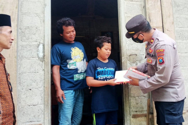 Kapolsek Kandangan Iptu Wahyu Hariyadi membagikan bantuan alat tulis kepada anak kurang mampu, Kamis (14/7/2022). (Foto: Dok. Istimewa)