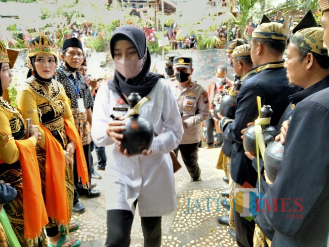 Camat Wonosari, Desy Ariyanti saat kendi berisi air yang diambil dari Sumber Agung.(Foto: Riski Wijaya/MalangTIMES).