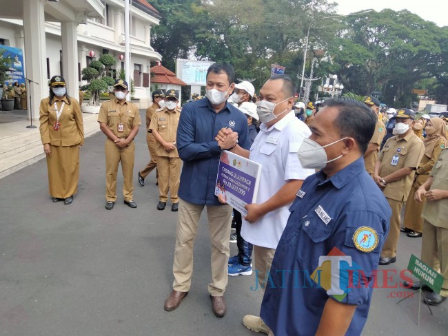 Ketua KONI Kota Malang Edi Wahyono menyerahkan secara simbolis reward bagi cabor peraih poin terbanyak.(Foto: Riski Wijaya/MalangTIMES).