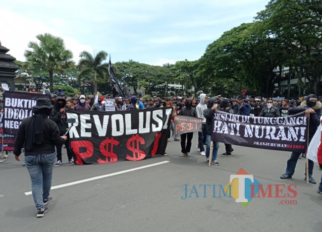 Massa aksi berbaju hitam saat melakukan aksi silent (foto: Hendra Saputra/JatimTIMES) 