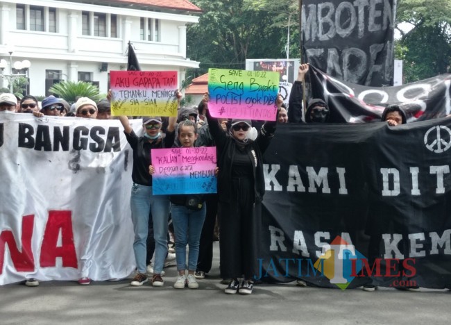 Massa aksi damai saat membentangkan tuntutannya melalui spanduk dan poster (foto: Hendra Saputra/JatimTIMES) 