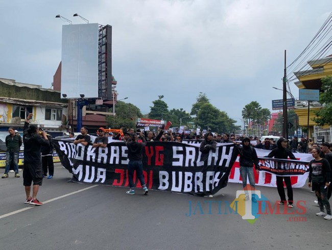 Aremania dan Arek Malang saat long march dalam aksi damai di Kota Batu, Selasa (1/11/2022). (Foto: Irsya Richa/MalangTIMES)