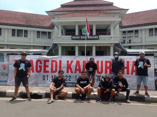 Sejumlah Aremania saat berfoto di banner rawat ingatan tragedi Kanjuruhan (foto: istimewa) 