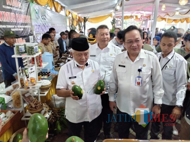 Bupati Malang HM. Sanusi didampingi Kepala DTPHP Kabupaten Malang Avicena menunjukan salah satu hasil pertanian.(Foto: Riski Wijaya/MalangTIMES).