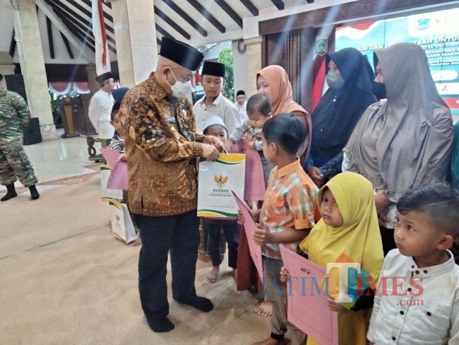 Bupati Malang HM. Sanusi memberikan santunan kepada anak yatim.(Foto: Riski Wijaya/MalangTIMES).