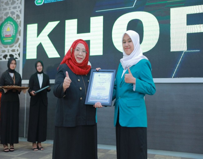 Dekan Fakultas Ekonomi dan Bisnis Universitas Islam Malang, Nur Diana SE MSi saat menyerahkan plakat kelulusan kepada salah satu wisudawan (foto: FEB Unisma for JatimTIMES) 