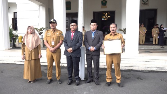 Walikota Malang Sutiaji didampingi Sekda Kota Malang Erik Setyo Santoso menyerahkan salah satu penghargaan.(Foto: Ahmad Amin/MalangTIMES).