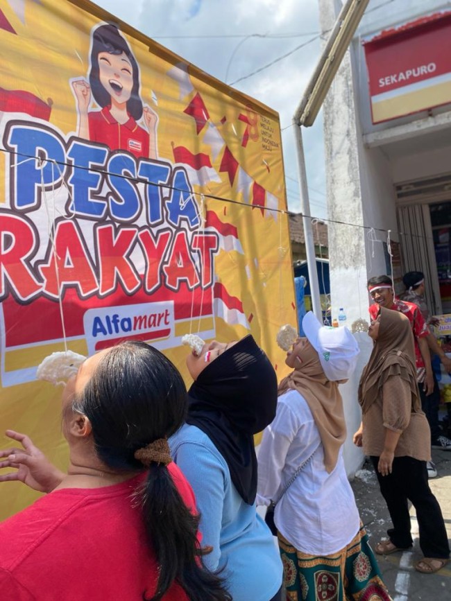 Tampak warga sekitar Alfamart Sekapuro, Pakis, Kab. Malang lomba makan kerupuk. (Foto: istimewa(