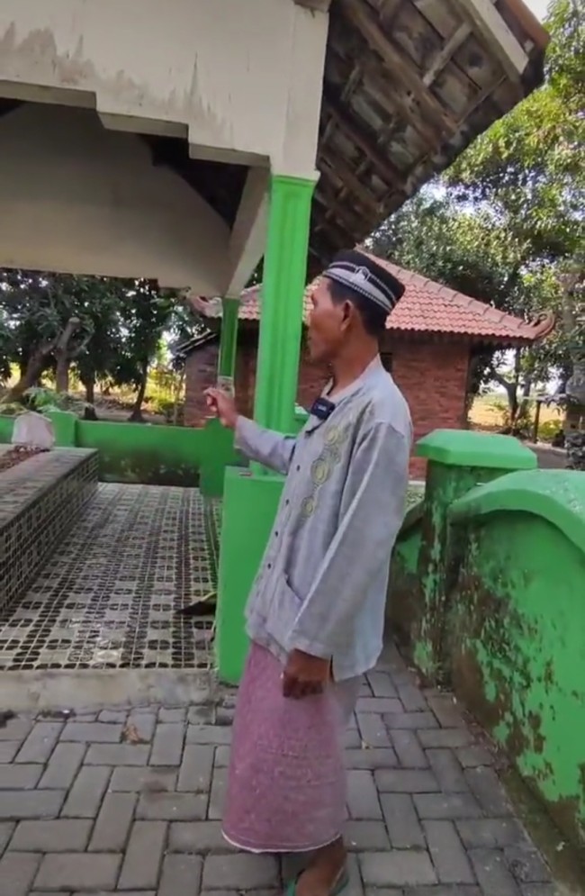 Juru kunci makam Mbah Cokro saat menjelaskan asal usul tak boleh jualan nasi di Desa Randegan. (Foto: TikTok)