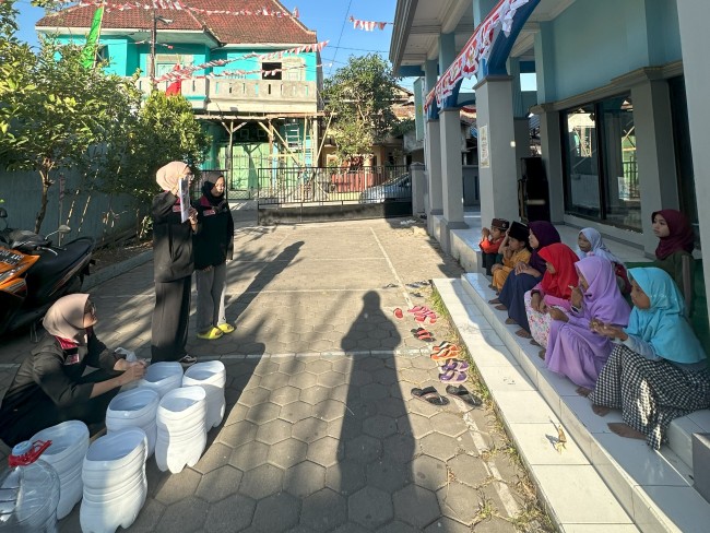 Mahasiswa PMM UMM Saat Melakukan Penyampaian Materi Tentang Tahapan Pembuatan Tempat Sampah Dari Galon Bekas