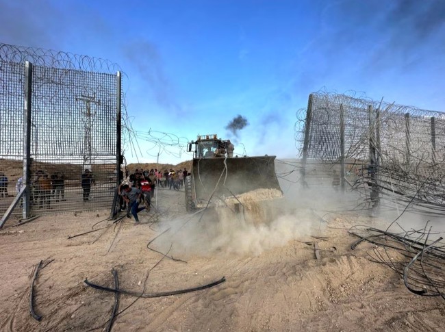 Warga Palestina menerobos pagar perbatasan Israel-Gaza sisi Israel setelah orang-orang bersenjata menyusup ke wilayah Israel selatan, 7 Oktober 2023. (REUTERS/Mohammed Fayq Abu Mostafa)