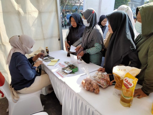 Warga mengantre untuk bisa mendapatkan sembako murah di stand milik Perumda Tunas Kota Malang.(Foto: Riski Wijaya/MalangTIMES).