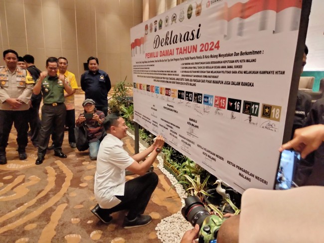 Pj Wali Kota Malang Wahyu Hidayat menandatangani pernyataan Deklarasi Damai Pemilu 2024.(Foto: Riski Wijaya/MalangTIMES).