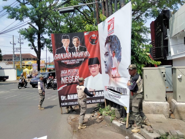 Penertiban reklame yang terpasang di trafic light.(Foto: Riski Wijaya/MalangTIMES).