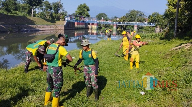 Anggota TNI dari Yon Arhanud 2 Kostrad saat membersihkan sekitaran Sungai Rolak (foto: Hendra Saputra/JatimTIMES)