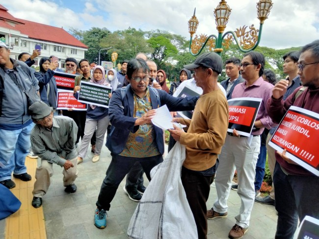 Aksi pemberian petisi kepada salah satu masyarakat sebagai salah satu simbol.(Foto: Riski Wijaya/MalangTIMES).