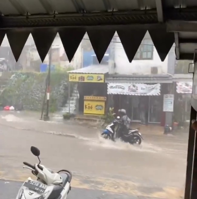Momen saat pengendara motor melawan arus banjir di Jalan Jupri, Bandulan, Kota Malang. (Foto: Infomalang)