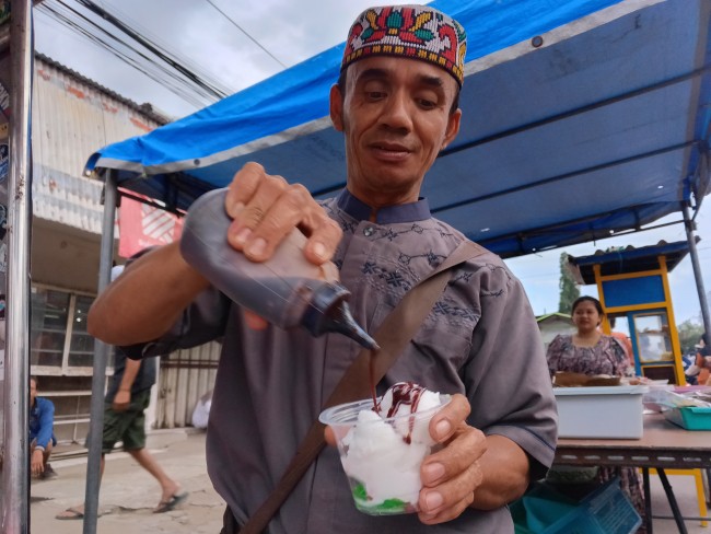 Pedagang es puter saat melayani pembeli di Pasar Takjil Ramadan pada kawasan Pasar Bululawang. (Foto: Ashaq Lupito / JatimTIMES)